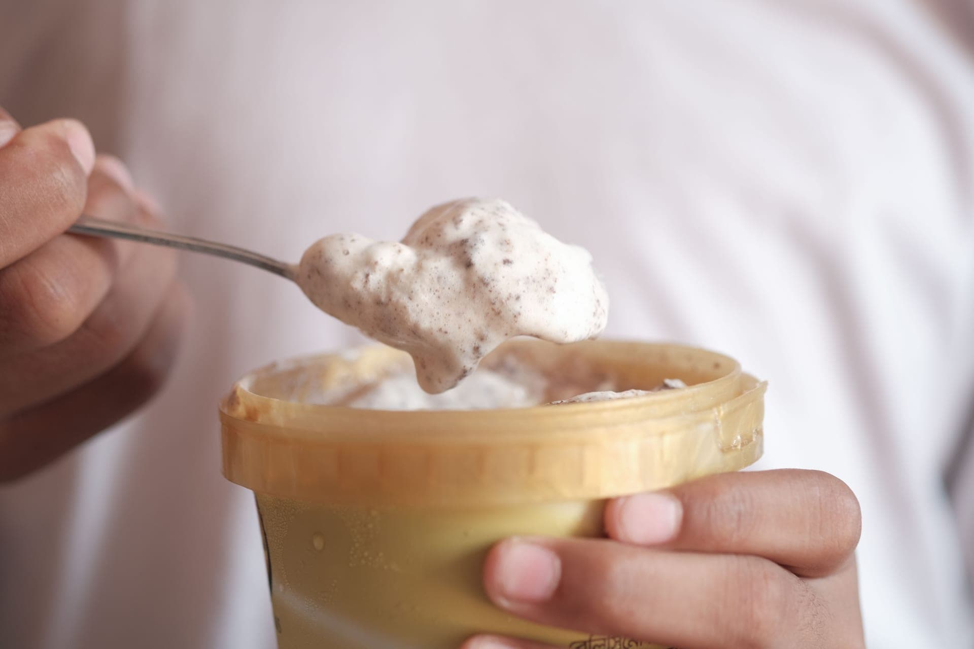 A spoonful of creamy ice cream lifted from a pint container